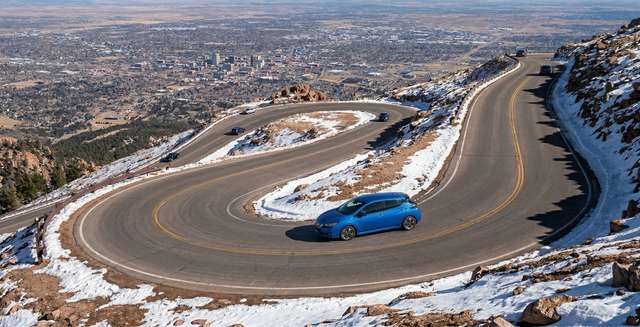 Nissan Leaf driving on Pikes Peak International Highway with Colorado Springs in the background